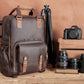 The Gaetano Large Leather Backpack Camera Bag with Tripod Holder beside DSLR cameras, showcasing secure compartments for photography gear and adjustable shoulder straps.