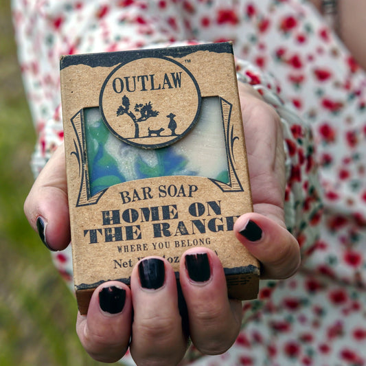 Hand holding a Craft Your Own Home on the Range Scent Soundtrack soap bar, embodying fresh-cut grass, laundry, and blackberry notes.