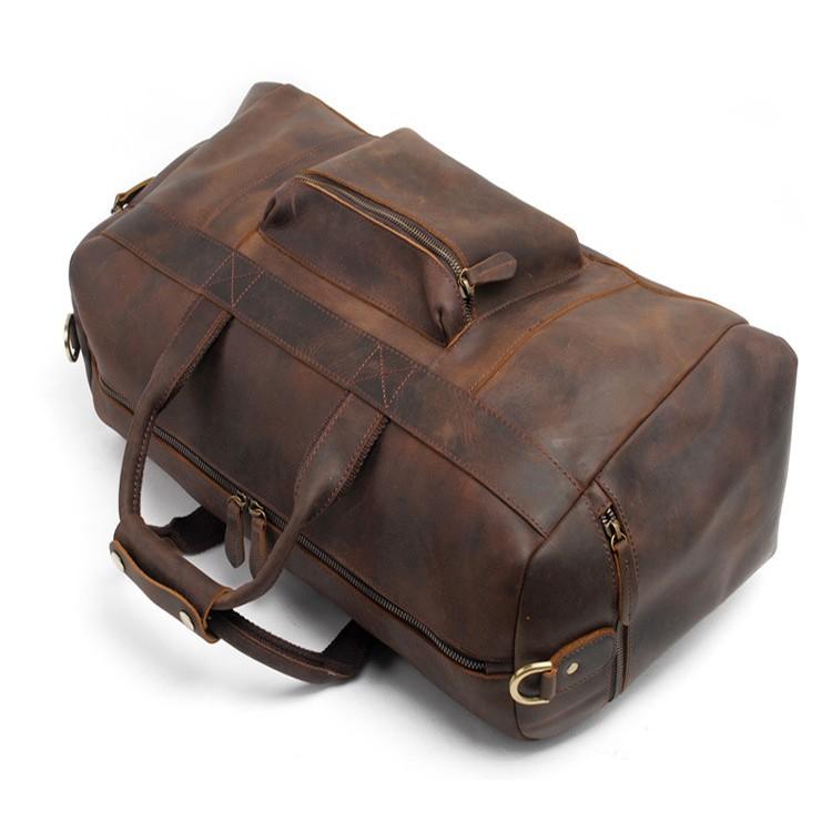 The Asta Weekender | Handcrafted Leather Duffle Bag with sturdy handles, featuring a leather-tipped zipper, front and side pockets, adjustable shoulder strap, and durable leather construction.