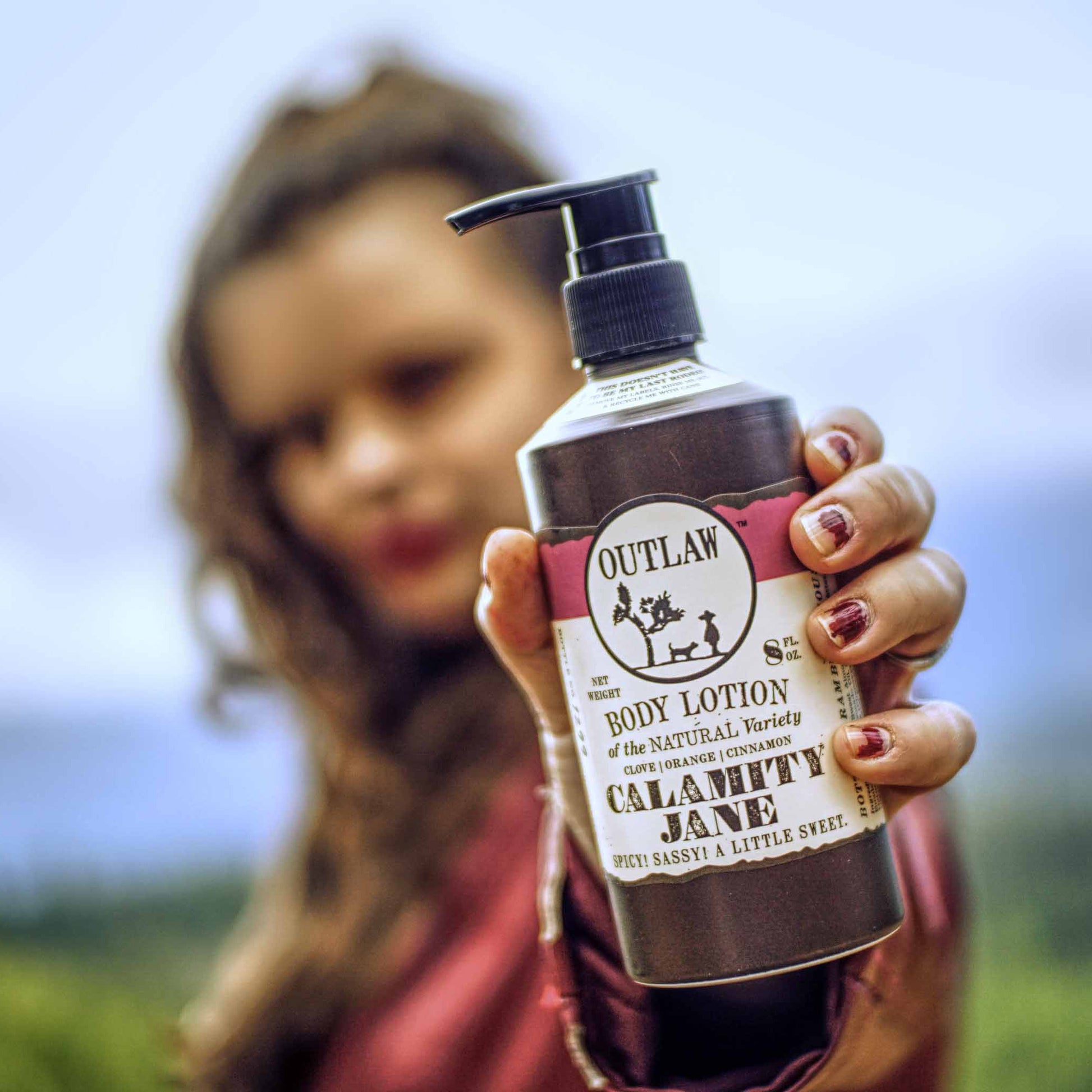 https://liveoutlaw.com/cdn/shop/products/Outlaw-Calamity-Jane-Clove-Natural-Lotion-clove-orange-cinnamon-whiskey-outdoors-hand-square.jpg?v=1605033577&width=1946